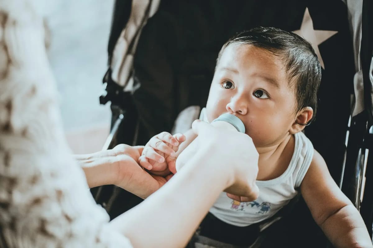 Parent bottle feeding an alert baby during the breastfeeding to bottle transition